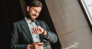 elegant-young-man-looks-at-wristwatch
